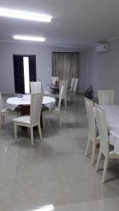 a dining room with white tables and white chairs at Valley Guest House in Pretoria