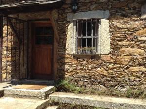 uma casa de pedra com uma porta e uma janela em SaberAmar Little Country em Arouca