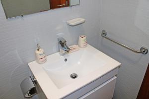 un bagno con un lavandino bianco e uno specchio di Trindade Oporto Apartments Group a Porto Altre 45 foto
