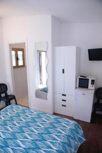 マリネッラ・ディ・サルザーナにあるAffittacamere Ambraのベッドルーム1室(ベッド1台、電子レンジ、鏡付)