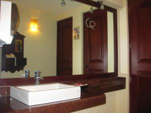 y baño con lavabo blanco y espejo. en Hotel CR Tehuacan, en Tehuacán