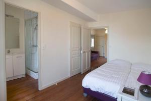 ニュイ・サン・ジョルジュにあるGites du Beffroiの白いベッドルーム(ベッド1台、バスルーム付)