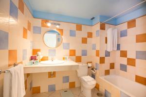 a bathroom with a sink and a toilet and a mirror at Apartamentos LIVVO Puerto de Mogán in Puerto de Mogán