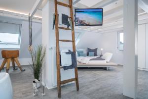 Zimmer mit einer Leiter mit einem Bett im Hintergrund in der Unterkunft Design-Studiowohnung Haegestrasse in Gütersloh