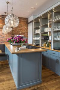 a kitchen with blue cabinets and a counter with flowers at Villa Stern in Oldenburg