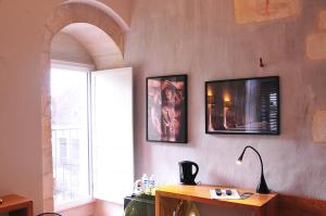 um quarto com uma mesa e uma televisão na parede em SY-la terrasse em Vézelay