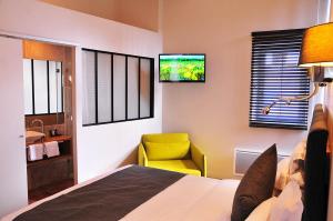 a bedroom with a bed and a yellow chair at SY-la terrasse in Vézelay