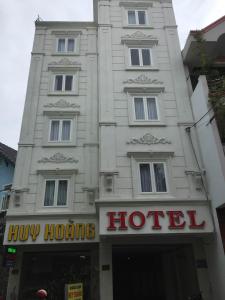 een wit gebouw met een hotelbord ervoor bij Huy Hoang 1 Hotel in Ho Chi Minh-stad