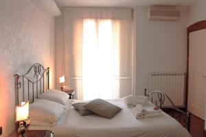 a bedroom with a bed with white sheets and a window at Villa Orchidea Luxury B&B in Ispica