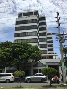 a tall building with cars parked in front of it at Apartamento Edificio Bahía Fragata in San Andrés