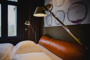 een hotelkamer met een bed met een lamp en een lamp bij Blue Inspired by Manna in Nijmegen