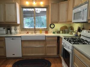 a kitchen with a sink and a stove and a window at Crossett Hill Lodge in Duxbury