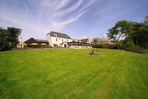 een groot wit huis met een groot groen veld bij Lochnell Arms Hotel in Oban