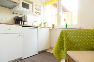 uma cozinha com armários brancos e uma cadeira verde em Ferienhaus nahe Uni Lueneburg em Lüneburg