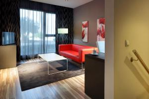 un soggiorno con divano rosso e tavolo di Eurostars Arenas de Pinto a Pinto