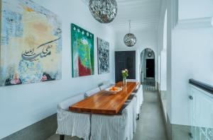 マラケシュにあるRiad Sapphire & Spaのダイニングルーム(白い椅子、木製テーブル付)
