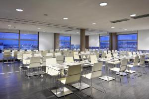 a conference room with tables and chairs and windows at Eurostars Arenas de Pinto in Pinto