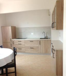 a kitchen with wooden cabinets and a sink and a table at Accommodation Vitalio in Umag