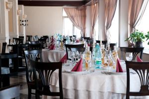 ein Esszimmer mit Tischen und Stühlen mit roten Servietten in der Unterkunft Hotel Rapsodia City Center in Botoşani