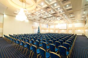 an empty hall with blue chairs and a christmas tree at Hotel Rapsodia City Center in Botoşani