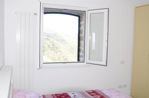 una finestra in una stanza con un letto di fronte di Corniglia - San Bernardino WiFi a San Bernardino