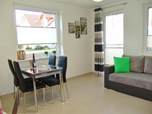 a living room with a table and chairs and a couch at Apartament Białe Piaski in Dębki