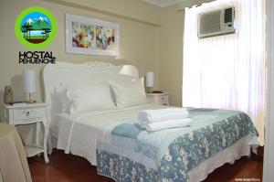 1 dormitorio con 1 cama con toallas en Hostal Pehuenche, en Talca