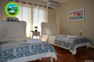 - une chambre avec 2 lits et une fenêtre dans l'établissement Hostal Pehuenche, à Talca