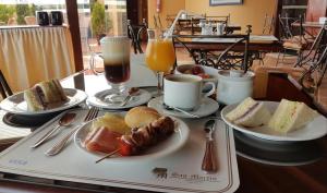 stół z talerzami jedzenia i napojów w obiekcie Apart Hotel San Martin w mieście Lima