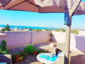 a patio with a table and an umbrella at Acquamarina Apartment with Terrace in Marsala