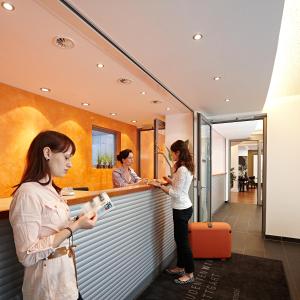 twee vrouwen aan een balie in een restaurant bij Internationales Studierendenhotel in Stuttgart