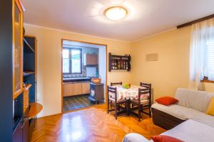 een woonkamer met een tafel en een keuken bij Apartment Manzoni in Malinska