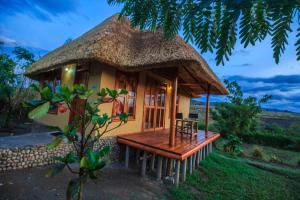 a small hut with a thatched roof at Wild Tracks Overland Camp in Kasese