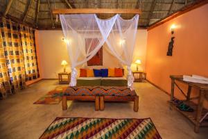 a living room with a bed and a canopy at Wild Tracks Overland Camp in Kasese