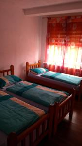 three beds sitting in a room with windows at Apartment Ana Marija in Mavrovo