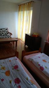 a room with two beds and a table and a chair at Apartment Ana Marija in Mavrovo