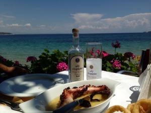 a table with a plate of food and a bottle of wine at Hotel Villa Nisteri in Limenas