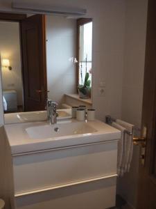 La salle de bains blanche est pourvue d'un lavabo et d'un miroir. dans l'établissement Tannenhof - Lofer, à Lofer