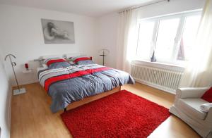 Schlafzimmer mit einem Bett und einem roten Teppich in der Unterkunft Ferienwohnung Döllinger Messe Fränkisches Seenland in Schwabach