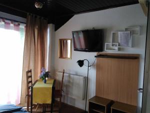 a bedroom with a table and a television on the wall at Rooms Hazler in Slunj +22 photos