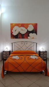 ガリポリにあるB&B Santa Luciaのベッドルーム1室(壁に絵画が描かれたオレンジ色のベッド1台付)