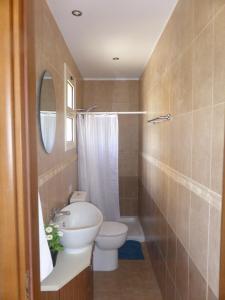 a bathroom with a sink and a toilet and a mirror at Aphrodite Sands Apartment D104 in Mandria