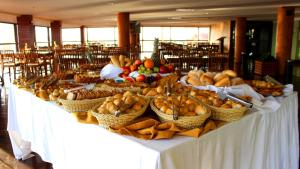 a long table with baskets of fruit on it at Natal Praia Hotel in Natal