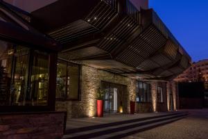 a building with a lit up facade at night at Puralã - Wool Valley Hotel & SPA in Covilhã