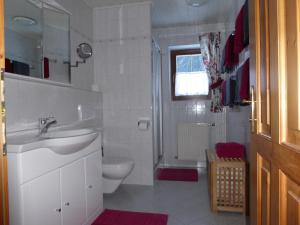 een witte badkamer met een wastafel en een toilet bij Ferienwohnung Vierthaler in Gosau +30 foto's