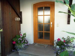 drzwi do domu z kwiatami przed nim w obiekcie Ferienhaus Irger w mieście Marquartstein