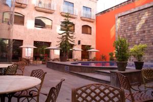 an outdoor patio with tables and chairs and a pool at Hotel Celta in Guadalajara