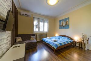 a bedroom with a bed and a couch at Parliament Apartment in Belgrade