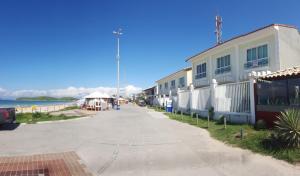 a street in front of a building next to the ocean at Casa NA PRAIA do Peró in Cabo Frio