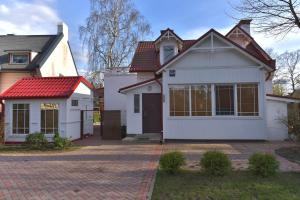 une maison blanche avec un toit rouge dans l'établissement Jurmala Guest House Markiza, à Jurmala